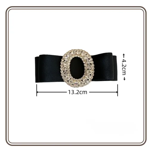 La Pince à Cheveux en Cristal Biscuit est une barrette à cheveux noire ornée d'une pièce centrale ovale décorative en or et strass. Cet accessoire élégant mesure 13,2 cm de large et 4,2 cm de haut, ce qui le rend parfait pour ajouter une touche de sophistication à n'importe quelle coiffure.