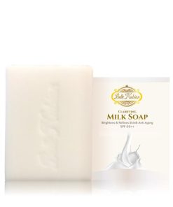 L'Ensemble Éclat Caramel, un savon au lait rectangulaire aux nuances de caramel, se trouve à côté de son emballage. Il promet des effets clarifiants, éclaircissants, affinants et anti-âge ainsi qu'un FPS 50++ pour apporter un éclat radieux à votre peau.