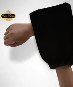 Une main portant le gant de gommage noir Routine Kinto Doigts Ultime, avec le logo Belle Nubian dans le coin supérieur gauche.