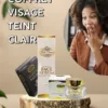 Une femme surprise se tient à côté d'un présentoir de produits de soins de la peau Coffret Visage Teint Clair, comprenant un sérum pour le visage, une crème exfoliante et un savon noir.