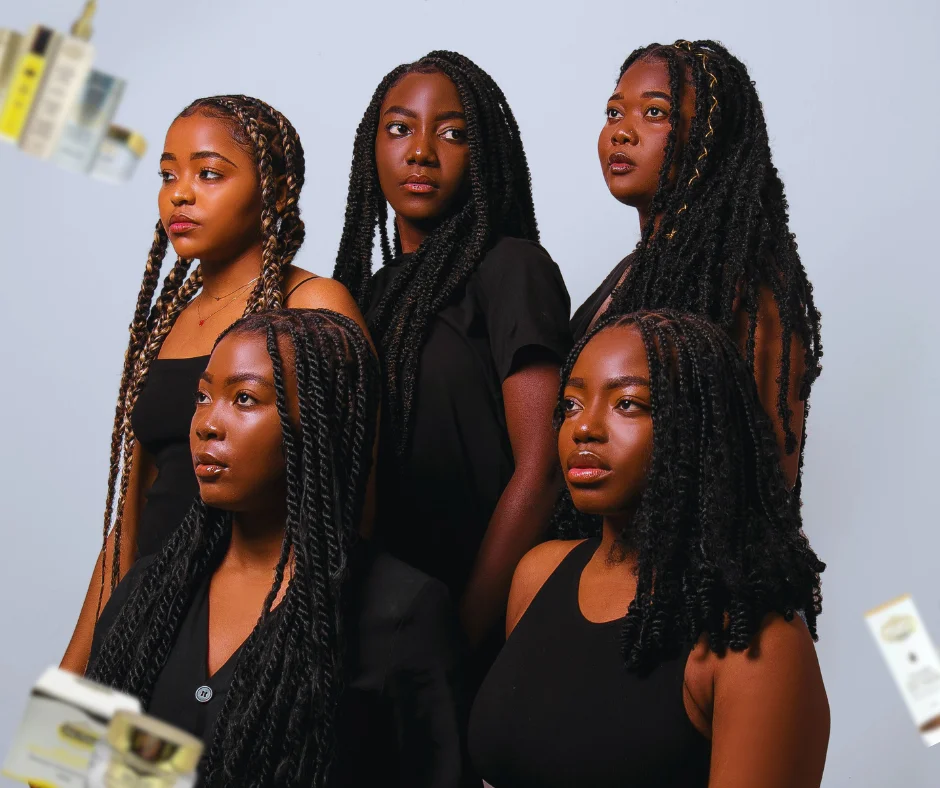 Cinq femmes aux coiffures tressées posent ensemble sur un fond clair, vêtues de tenues noires. Des flacons de soins éclatants de Belle Nubian Canada sont visibles sur les bords de l'image, mettant en valeur les soins du visage et les soins capillaires essentiels.